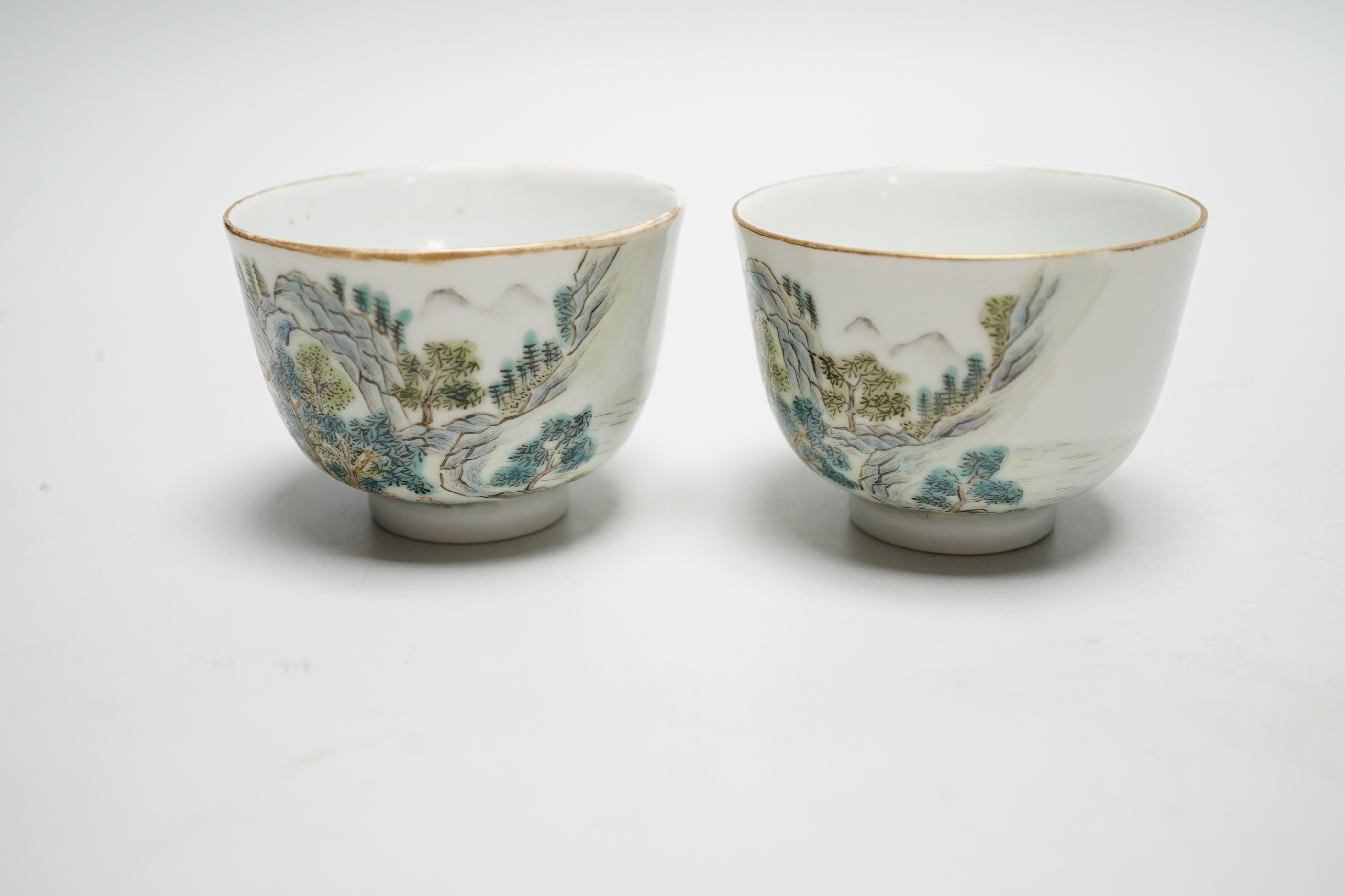 A pair of Chinese enamelled porcelain cups, landscapes and pagodas, 6cm tall